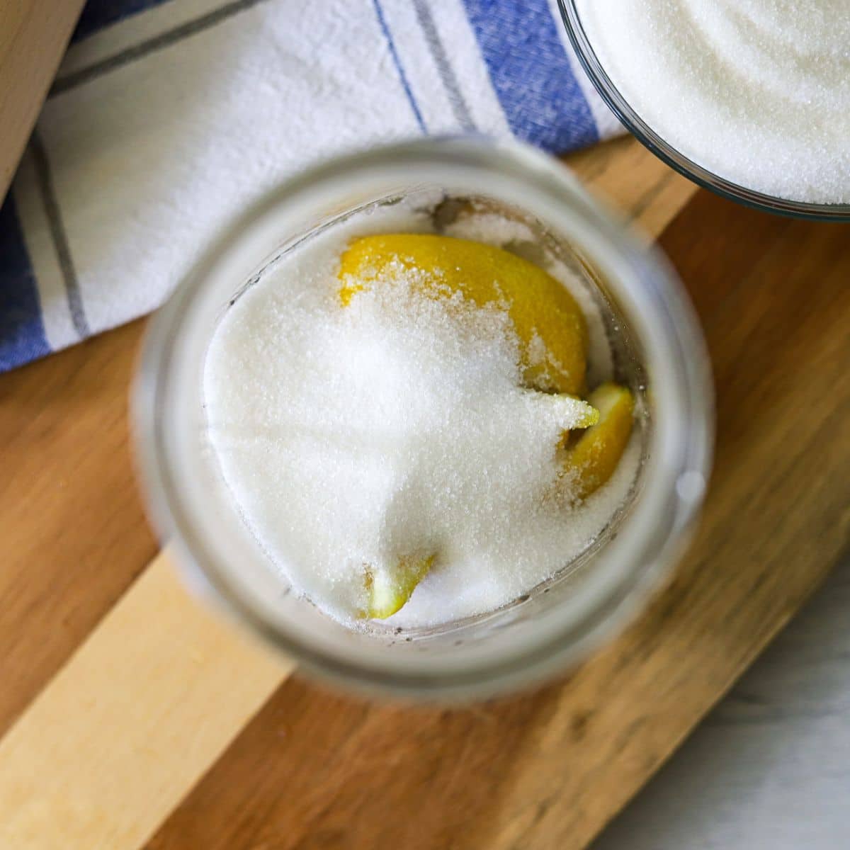 sugar and lemon wedges in the bottom of a mason jar.